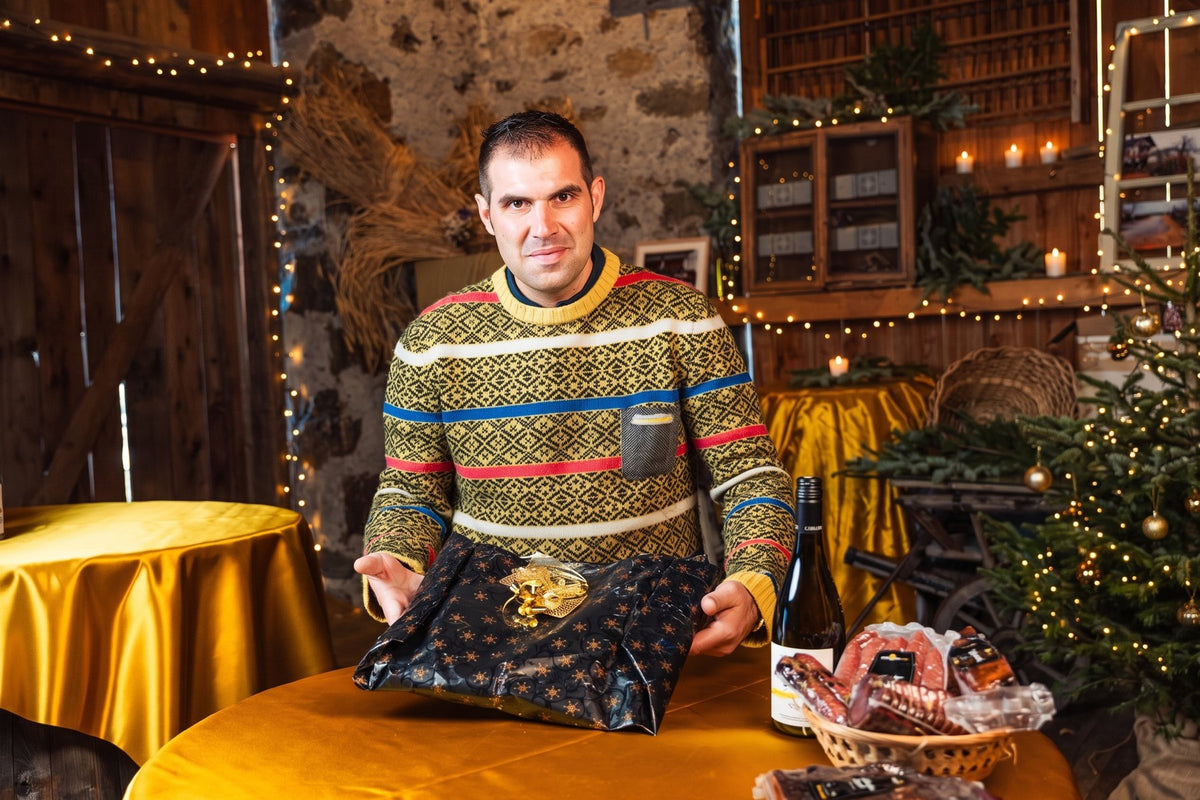 Alexander Kaserer mit verpacktem Geschenk in der weihnachtlichen Stube